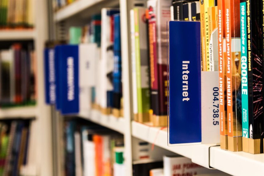 Estante de biblioteca com livros sobre internet e tecnologia, representando a relação entre leitura e cultura digital.