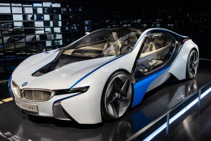 Carro esportivo branco exposto em um showroom, sob iluminação interna.