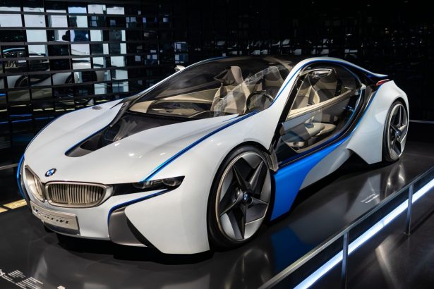 Carro esportivo branco exposto em um showroom, sob iluminação interna.