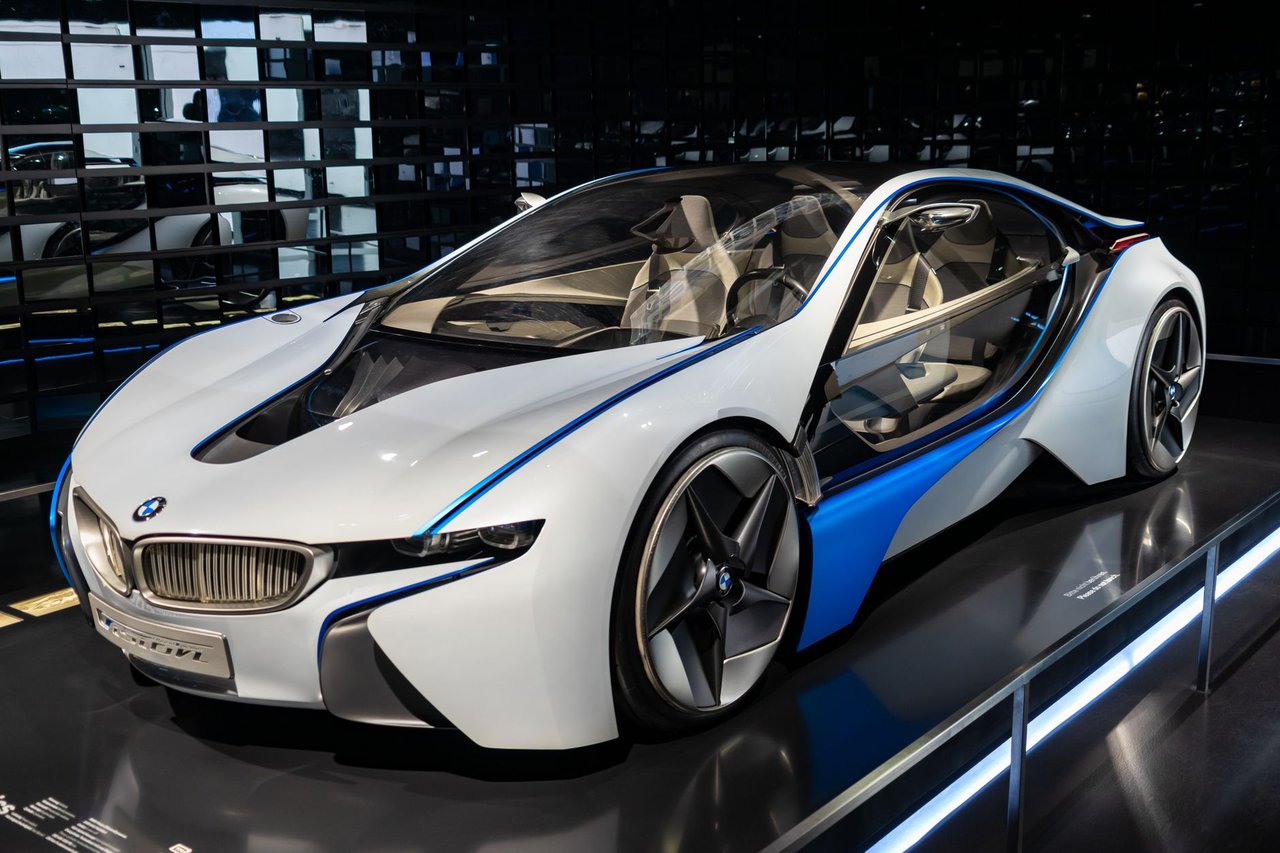 Carro esportivo branco exposto em um showroom, sob iluminação interna.