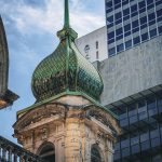 Conjunto arquitetônico em São Paulo que combina uma construção histórica ornamentada com estruturas modernas ao fundo.
