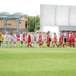 Jogadoras de futebol feminino se cumprimentam no campo antes de uma partida.