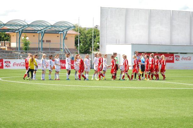Jogadoras de futebol feminino se cumprimentam no campo antes de uma partida.